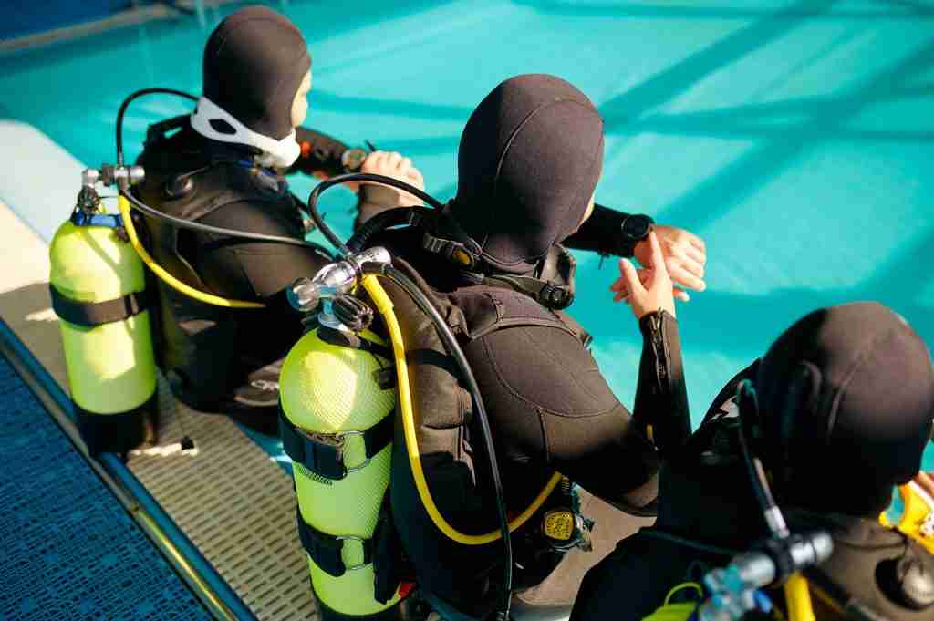 divemaster and two divers preparing for the dive BJYNPU8