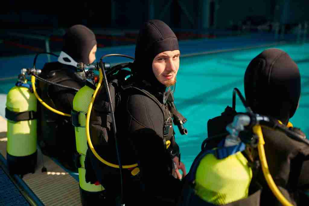 divemaster and two divers preparing for the dive MMBC7ZM