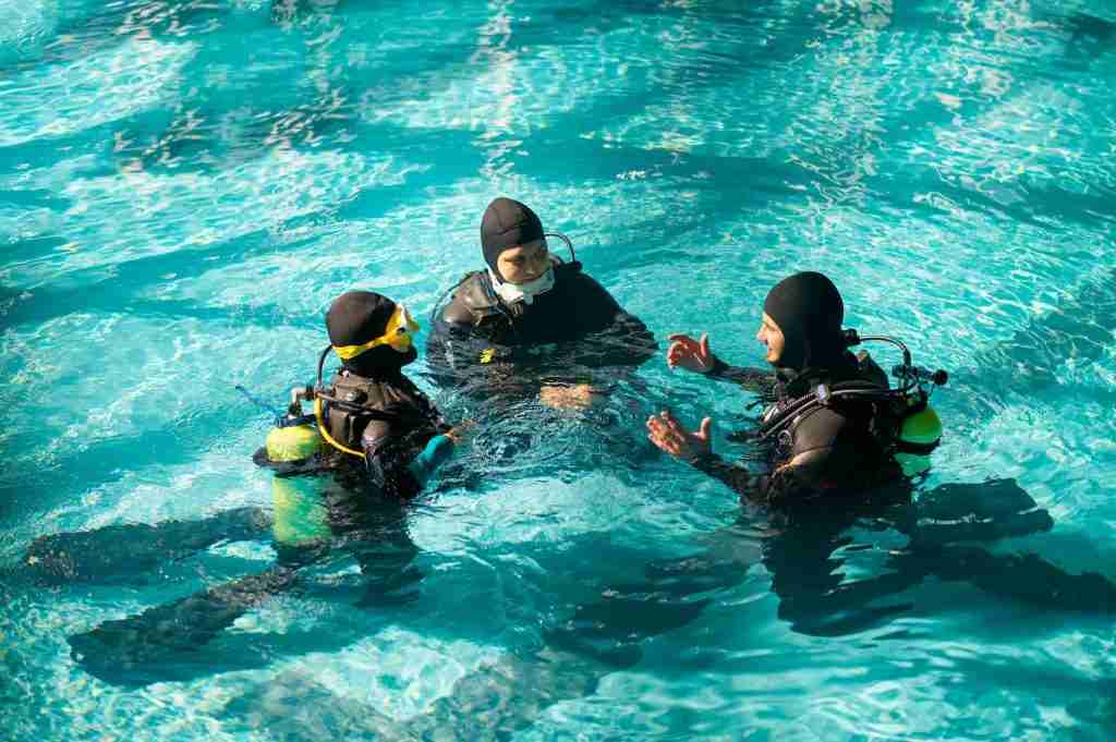 Instructor and divers in aqualungs, dive course